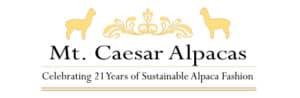 Mt. Caesar Alpacas logo with two gold alpacas, an ornate crest, and the tagline 'Celebrating 21 Years of Sustainable Alpaca Fashion'.